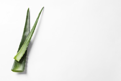 Photo of Green aloe vera leaves on white background, top view. Space for text