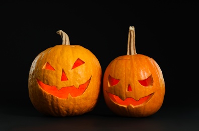 Photo of Pumpkin heads on black background. Jack lantern - traditional Halloween decor