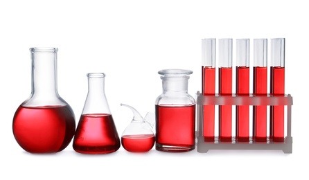 Photo of Set of laboratory glassware with red liquid on white background