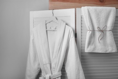 Hanger with clean bathrobe and towel on screen
