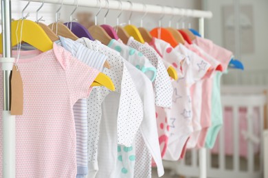 Photo of Baby clothes hanging on rack in store. Shopping concept