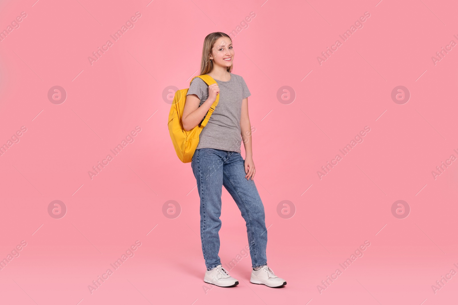 Photo of Teenage girl with backpack on pink background