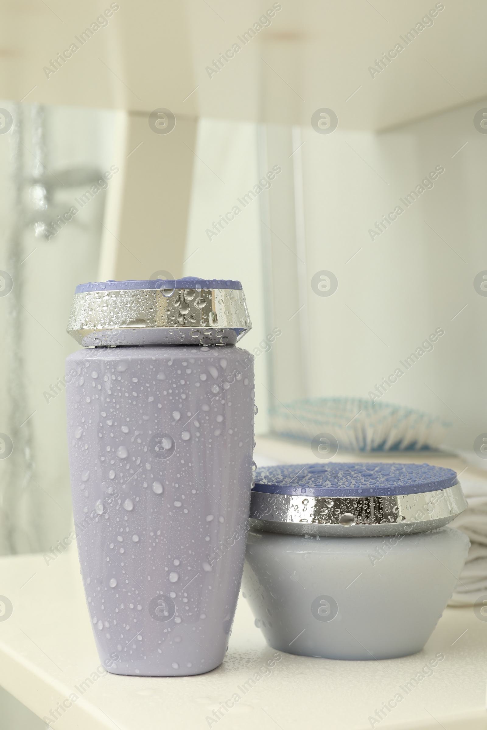 Photo of Hair care cosmetic products on white shelf indoors