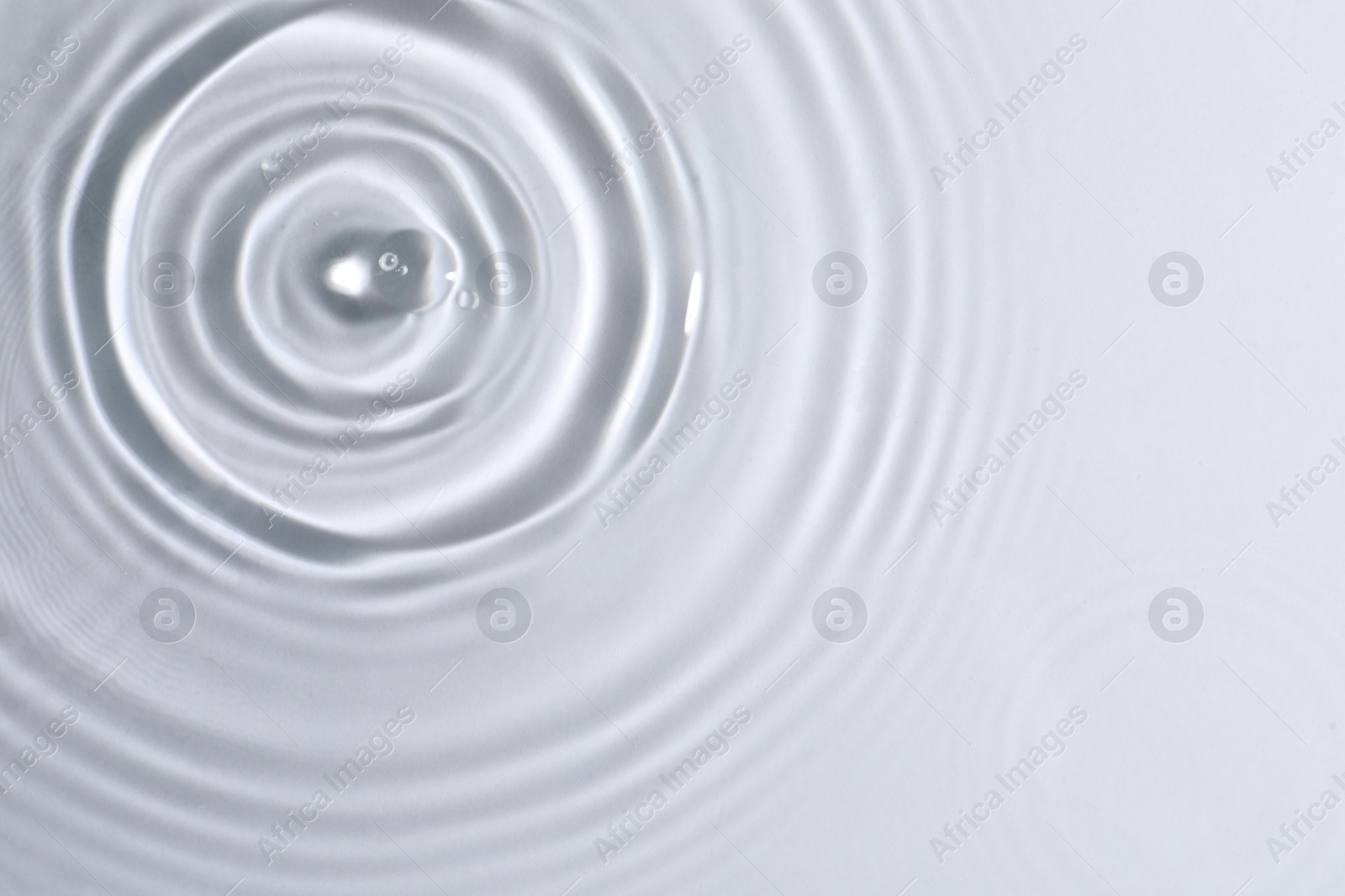 Photo of Closeup view of water with circles on light background