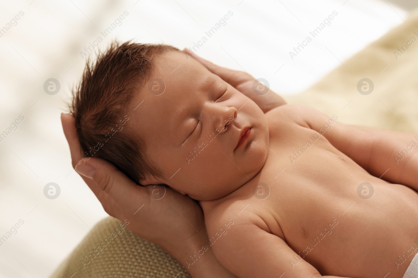 Photo of Mother holding her cute newborn baby indoors, closeup