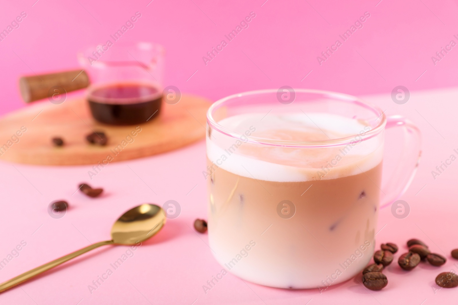 Photo of Cup of fresh coffee and beans on pink table, closeup