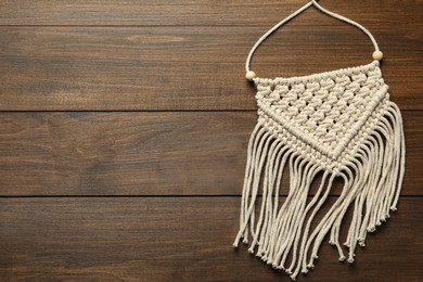 Photo of Stylish beige macrame on wooden table, top view. Space for text