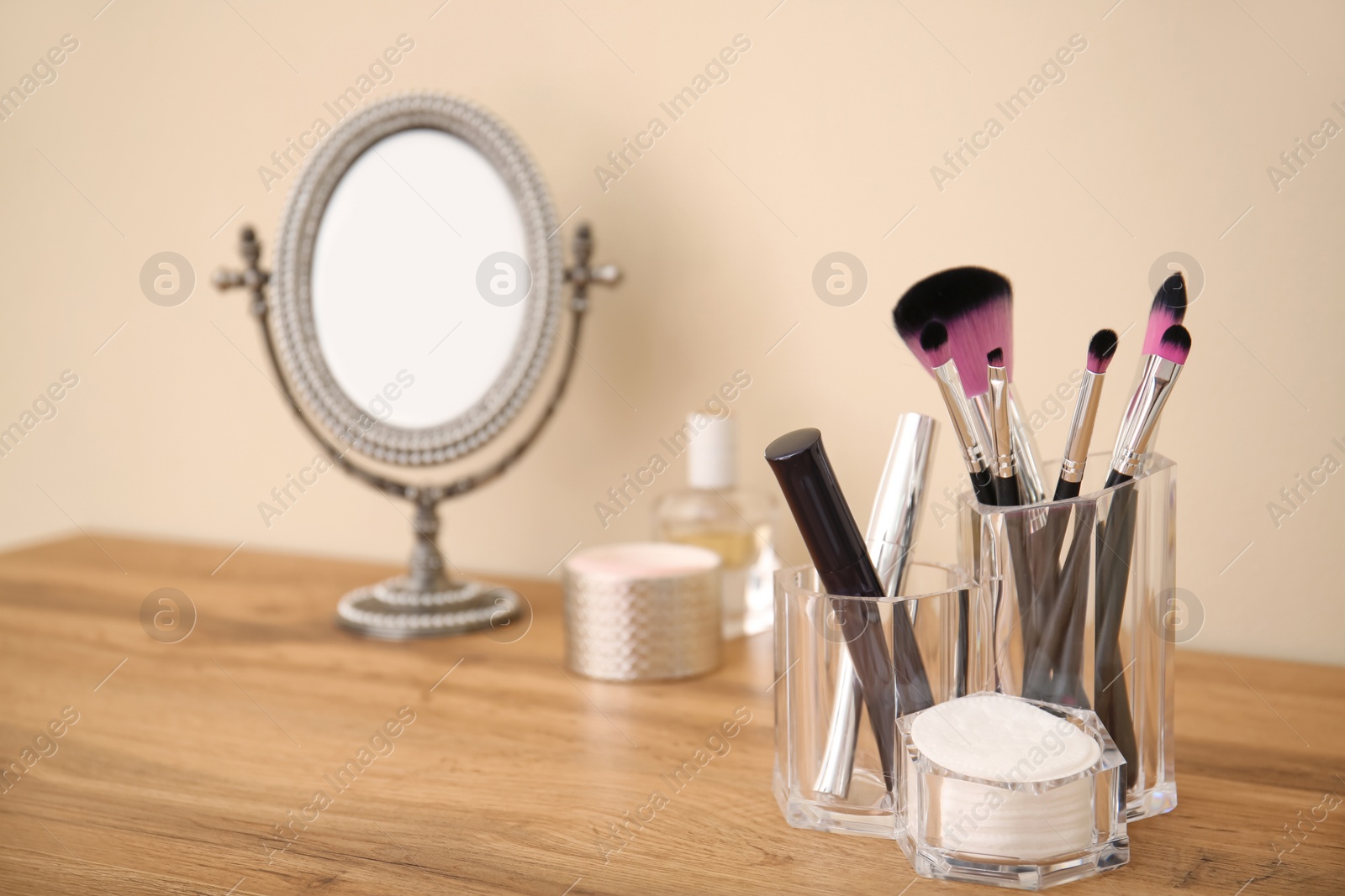 Photo of Makeup cosmetic products and tools in organizer on dressing table
