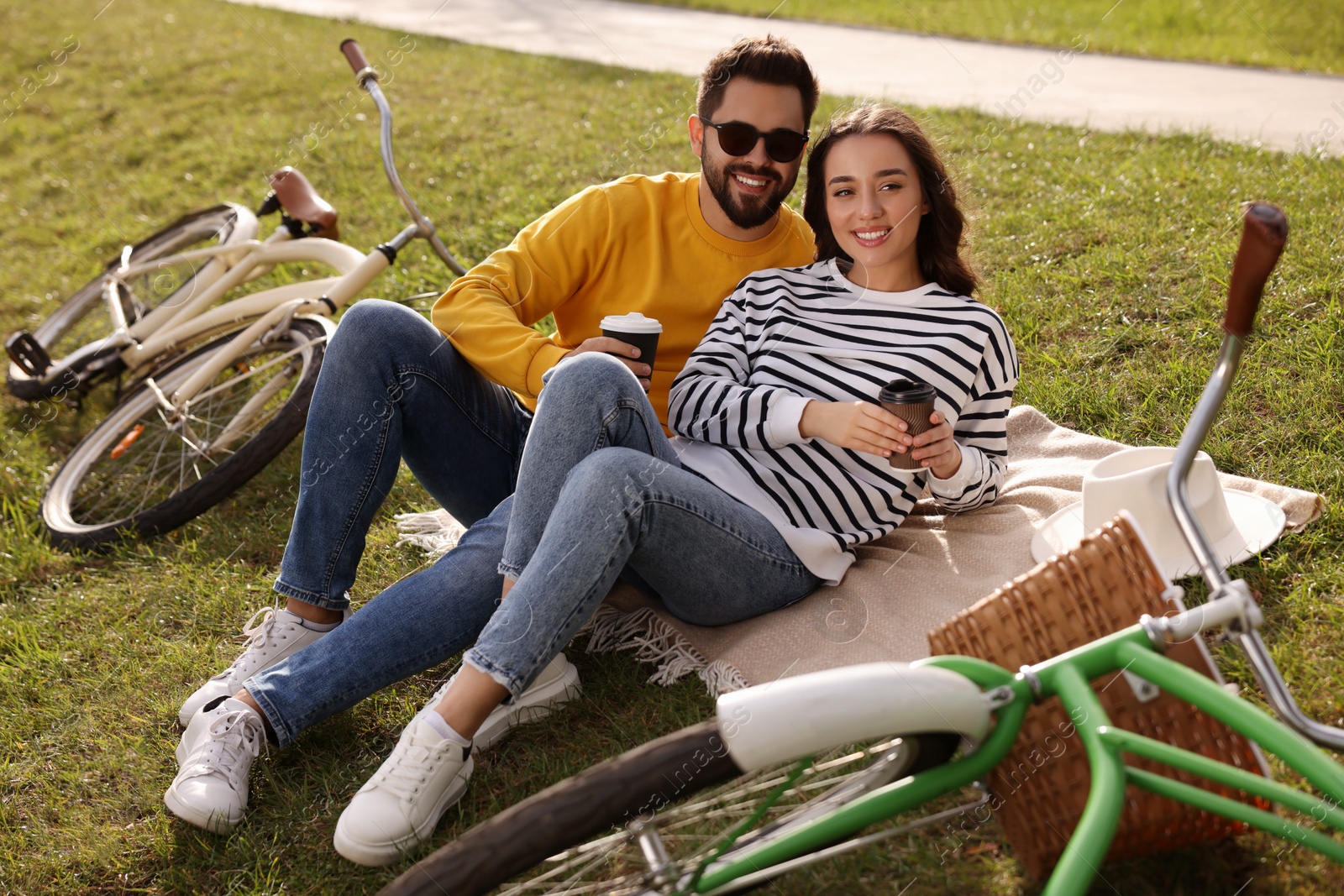 Photo of Beautiful young couple with takeaway coffee spending time together outdoors