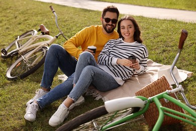 Photo of Beautiful young couple with takeaway coffee spending time together outdoors