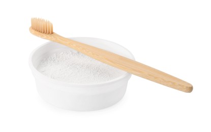 Bowl of tooth powder and brush on white background