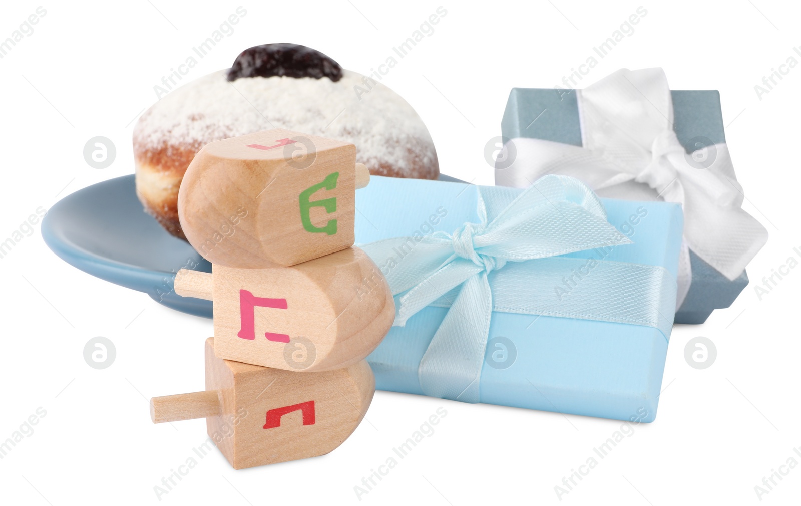 Photo of Hanukkah celebration. Wooden dreidels with jewish letters, gift boxes and donut isolated on white