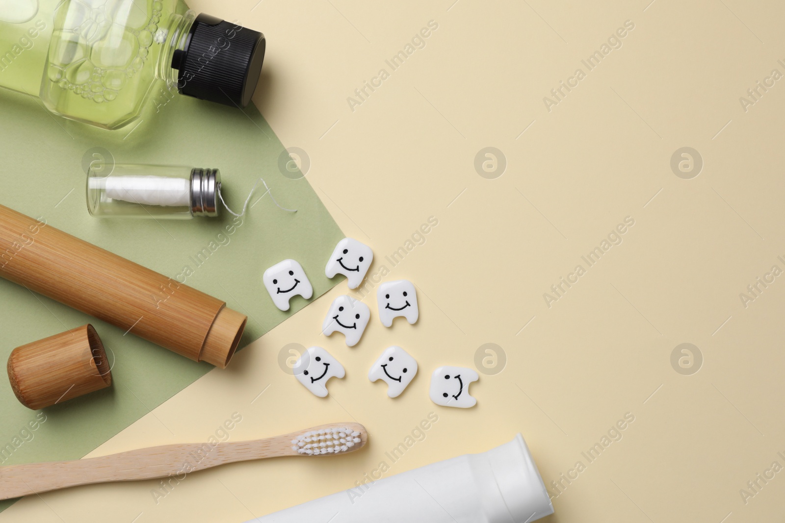 Photo of Plastic teeth with cute faces, oral care products and dental tools on color background, flat lay. Space for text