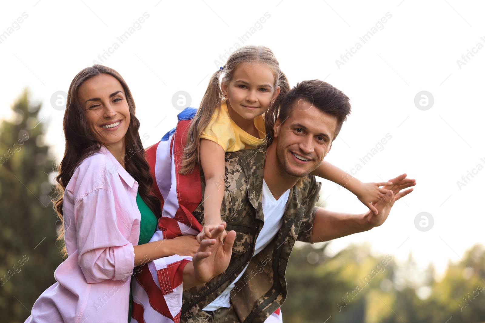 Photo of Man in military uniform and his family at sunny park