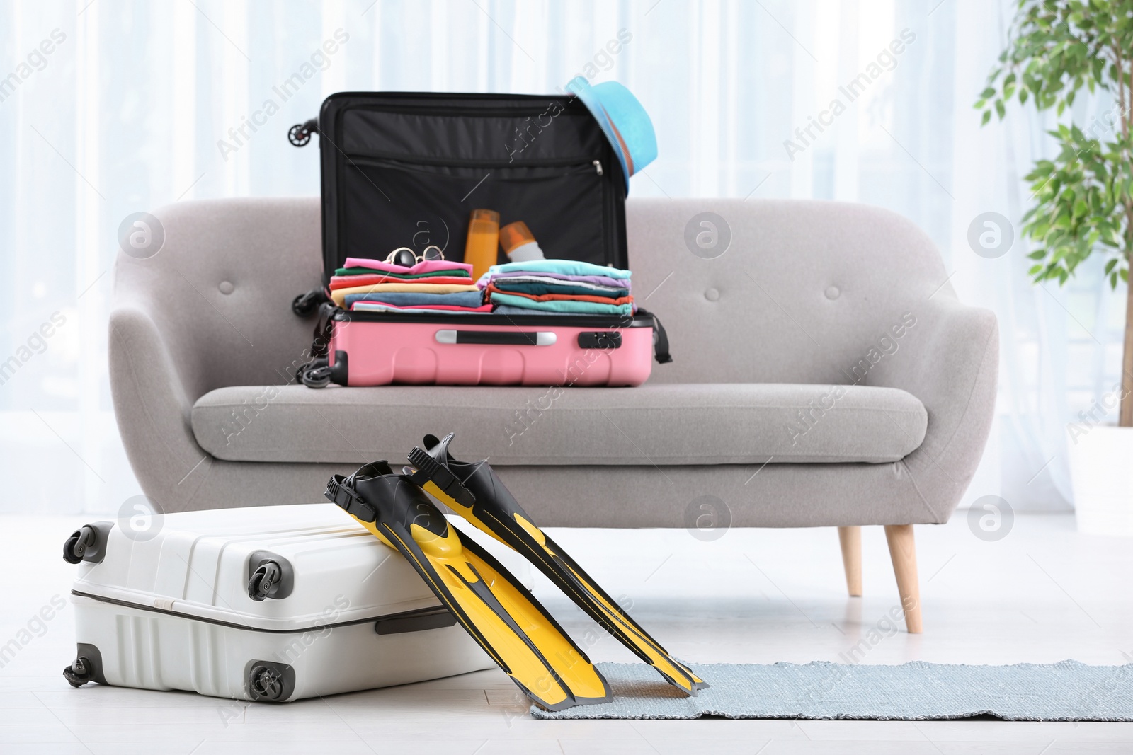 Photo of Modern suitcases packed for journey on sofa indoors