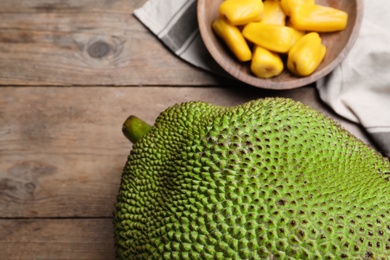 Photo of Fresh exotic jackfruit on wooden table, above view