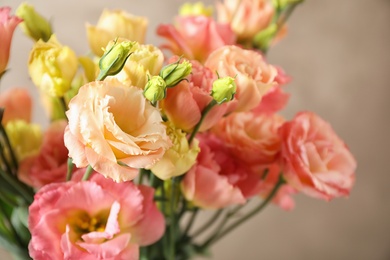 Photo of Beautiful Eustoma flowers against beige background, closeup