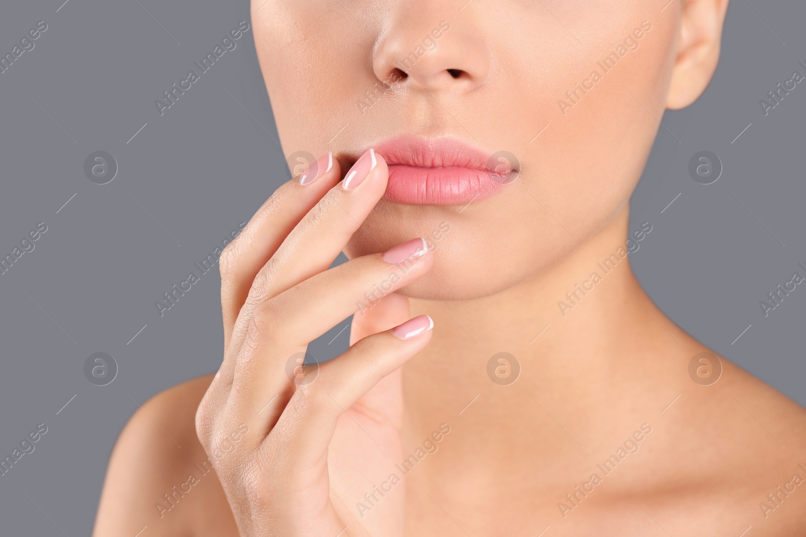 Photo of Closeup view of beautiful young woman on grey background. Lips contouring, skin care and cosmetic surgery concept