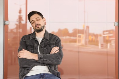 Tired man sleeping at public transport stop outdoors. Space for text