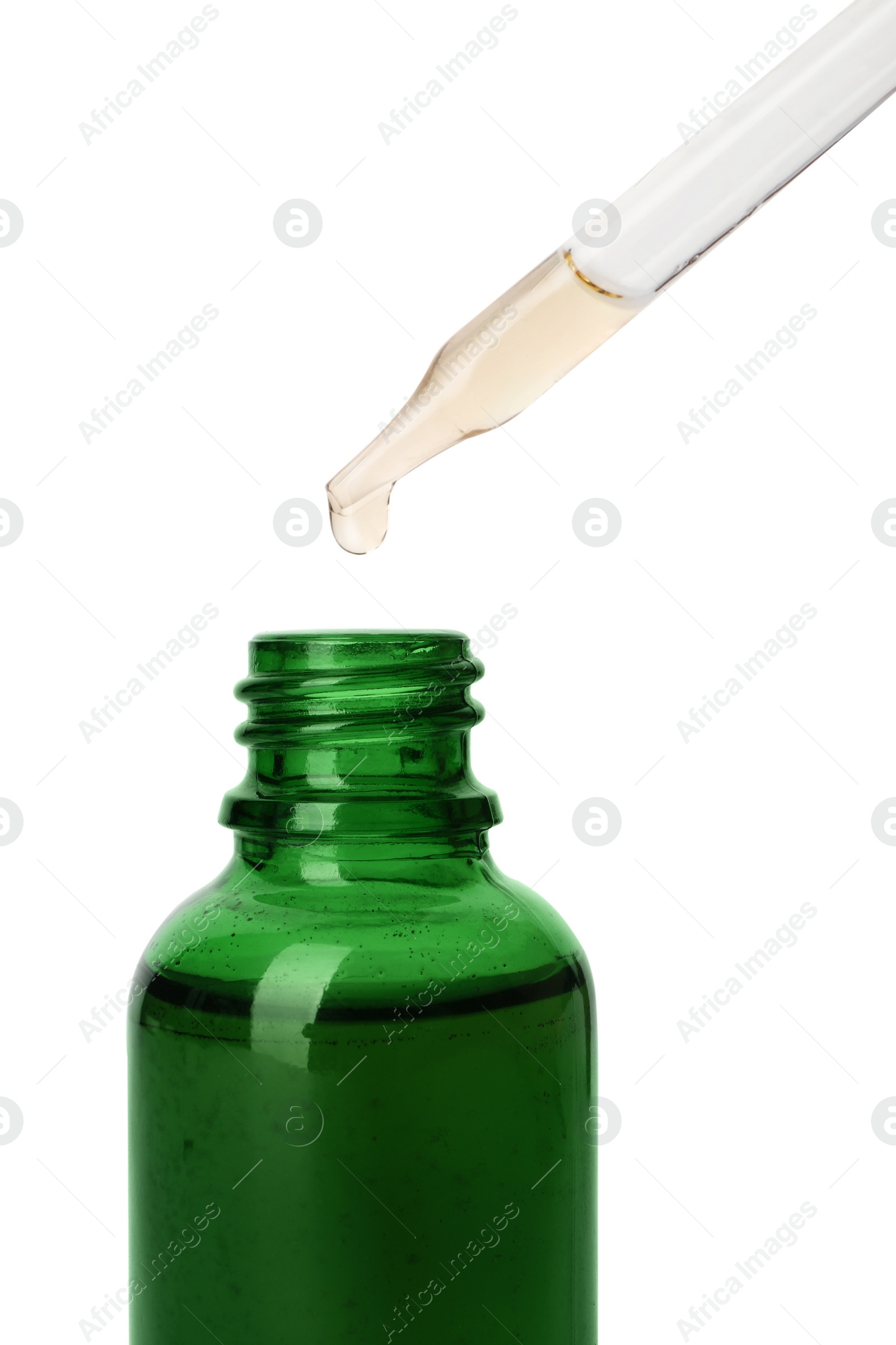 Photo of Essential oil dripping from pipette into glass bottle on white background