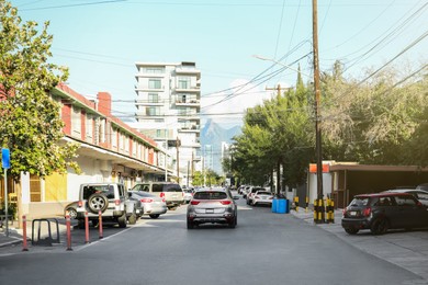 Photo of Picturesque view of city street with cars on road near beautiful buildings