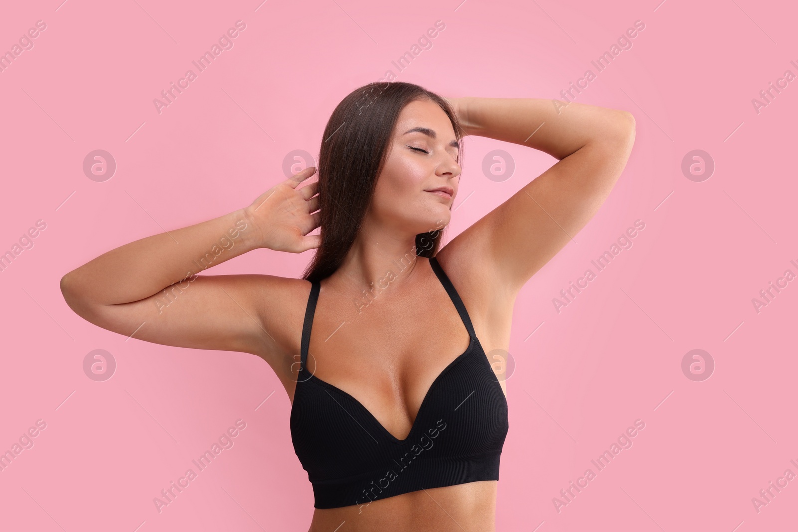 Photo of Portrait of young woman with beautiful breast on pink background