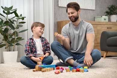 Photo of Happy dad and son playing with cubes at home