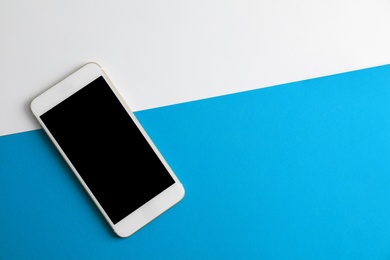 Photo of Modern phone on color background, top view. Space for text