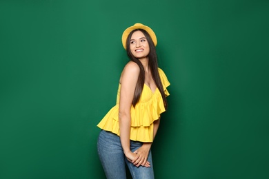 Portrait of beautiful young woman in stylish clothes on color background