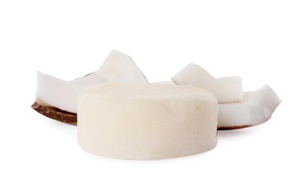 Solid shampoo bar and coconut pieces on white background. Hair care