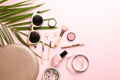 Flat lay composition with products for decorative makeup on pastel pink background