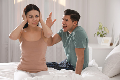 Photo of Couple with relationship problems quarreling in bedroom