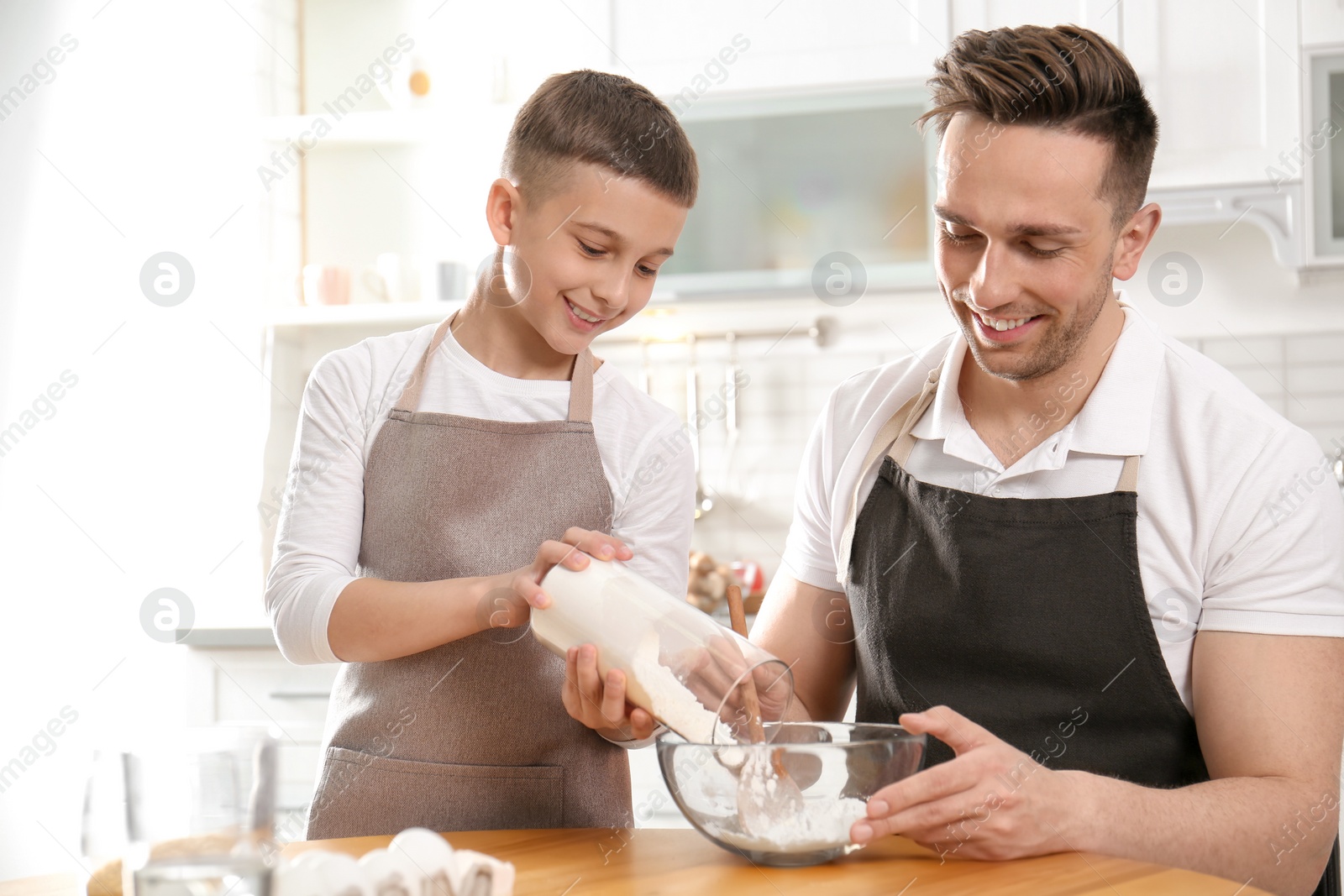 Photo of Dad and son cooking together in kitchen