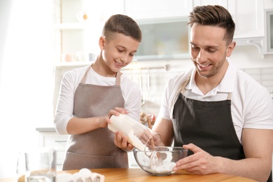 Photo of Dad and son cooking together in kitchen