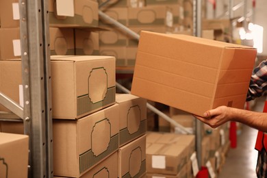 Worker stacking boxes in warehouse, closeup. Wholesaling