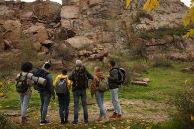 Photo of Group of hikers with backpacks in mountains, back view