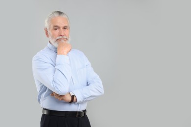 Photo of Portrait of handsome senior man on light grey background. Space for text