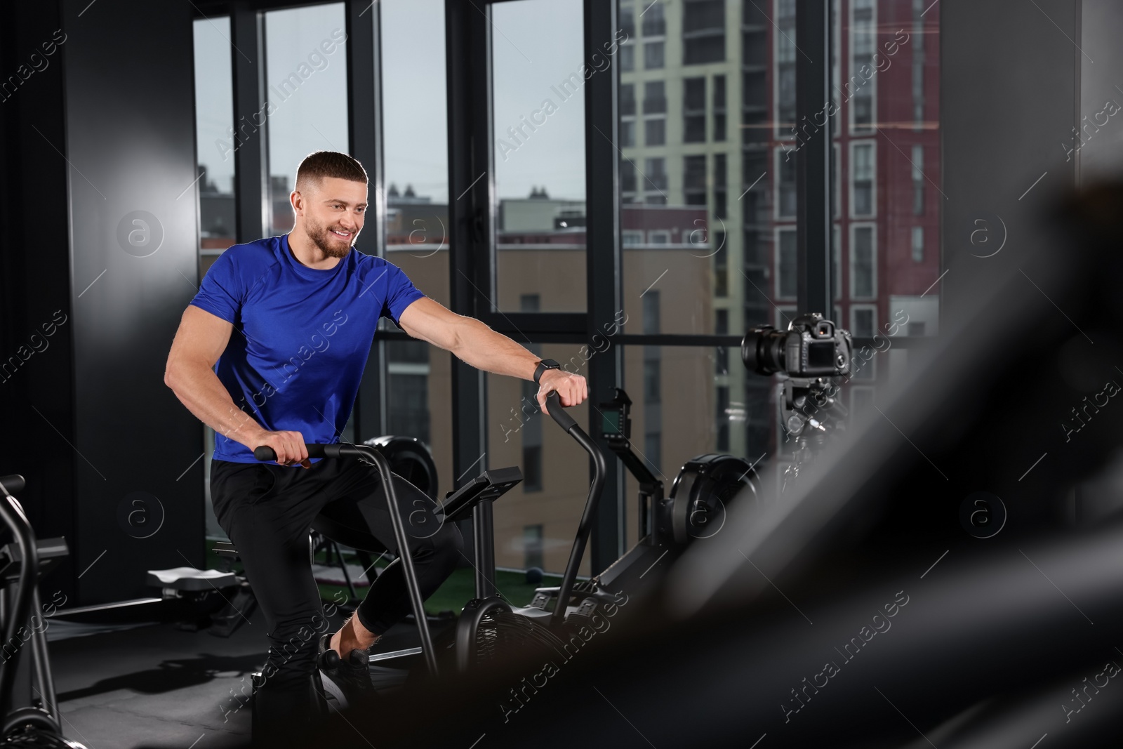 Photo of Man recording workout on camera at gym. Online fitness trainer