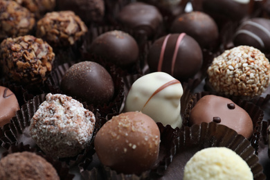 Photo of Different tasty chocolate candies as background, closeup