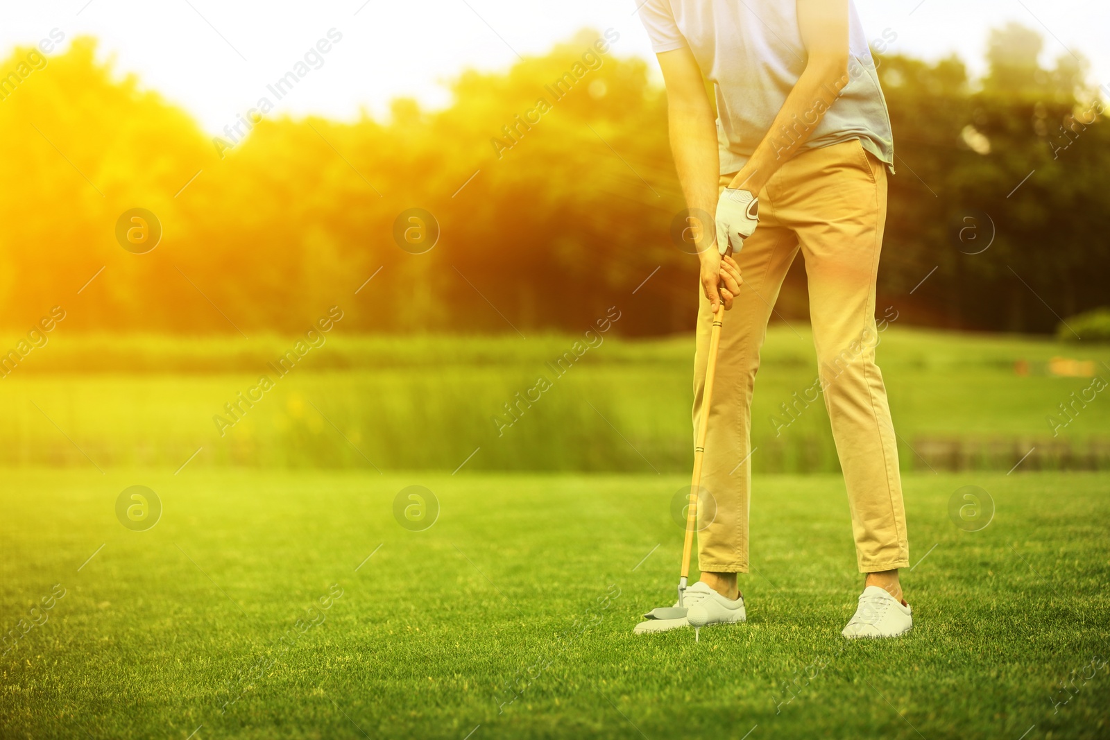 Image of Man playing golf in park on sunny day. Space for design