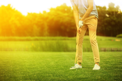 Image of Man playing golf in park on sunny day. Space for design