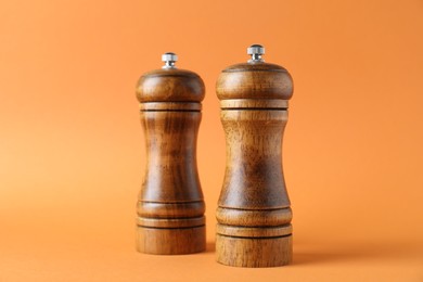 Photo of Wooden salt and pepper shakers on orange background