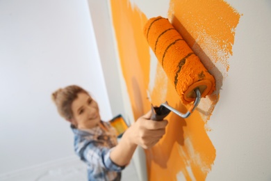 Happy woman painting wall indoors, above view. Home repair