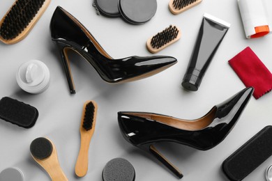 Flat lay composition with shoe care accessories and footwear on light grey background