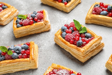 Fresh delicious puff pastry with sweet berries on grey table