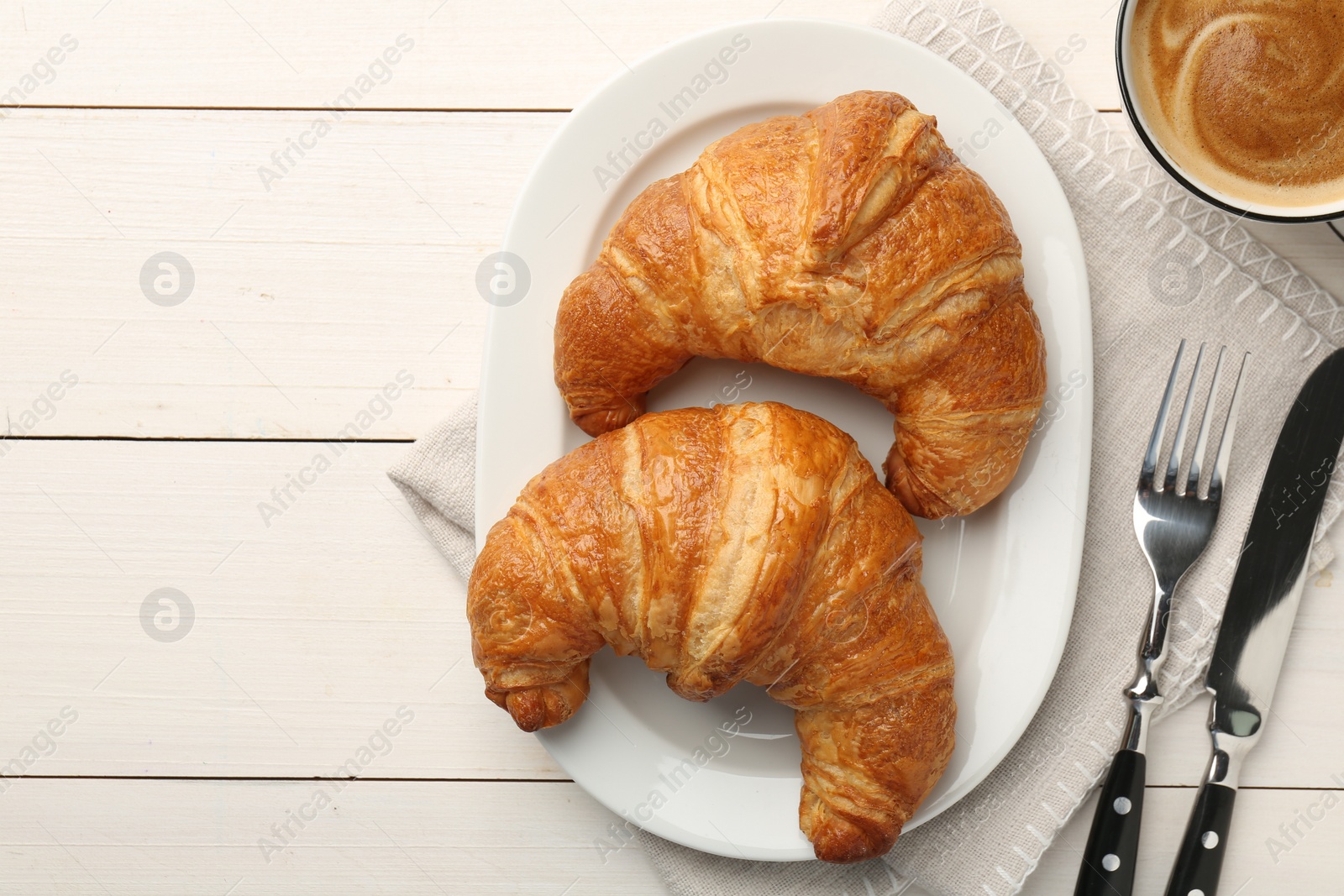 Photo of Delicious fresh croissants served on white wooden table, flat lay. Space for text