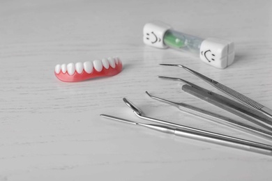 Composition with different dentist tools on wooden table, closeup