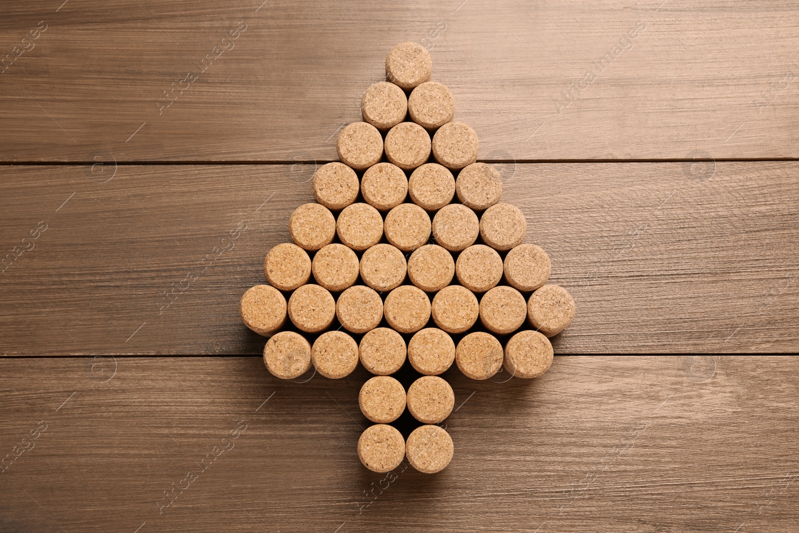 Photo of Christmas tree made of wine corks on wooden table, top view