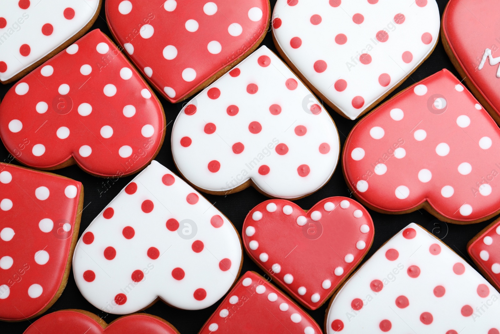 Photo of Delicious heart shaped cookies on dark background, flat lay. Valentine's Day