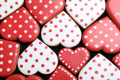 Delicious heart shaped cookies on dark background, flat lay. Valentine's Day